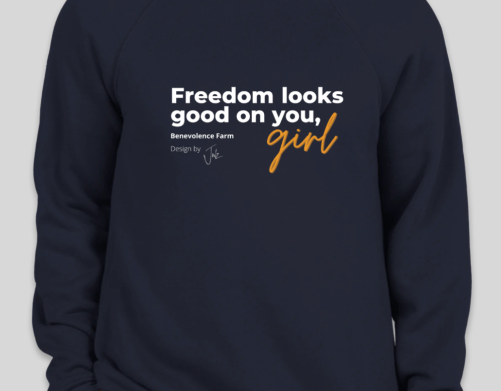 Navy hoodie with the text "Freedom looks good on you, girl. Benevolence Farm. Design by Julz"
